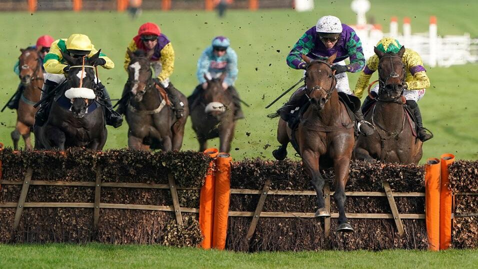 Runners take a fence at the Cheltenham Festival